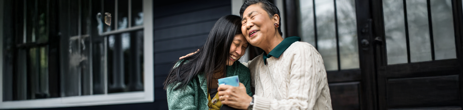 two woman hugging on porch