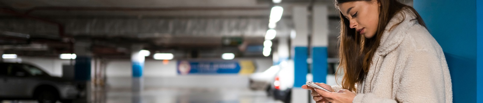 Woman using phone in parking lot