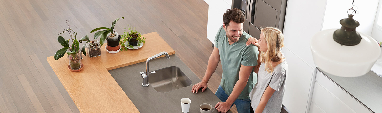 Young couple in modern kitchen with laptop